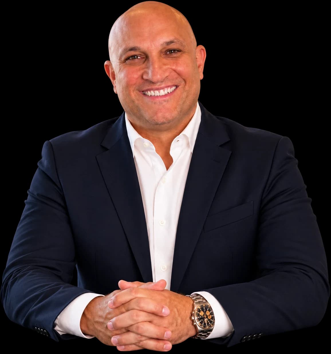 Golan Gedalya, smiling, in a navy jacket and an open white shirt, hands folded